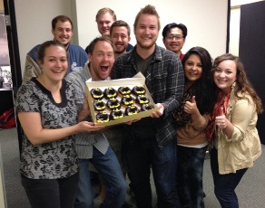 marketing team holding box of penguin donuts